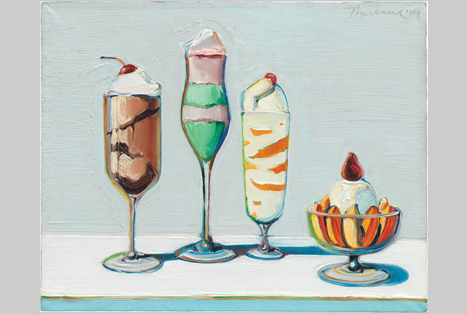 Four ice cream sundaes in different shaped glasses.