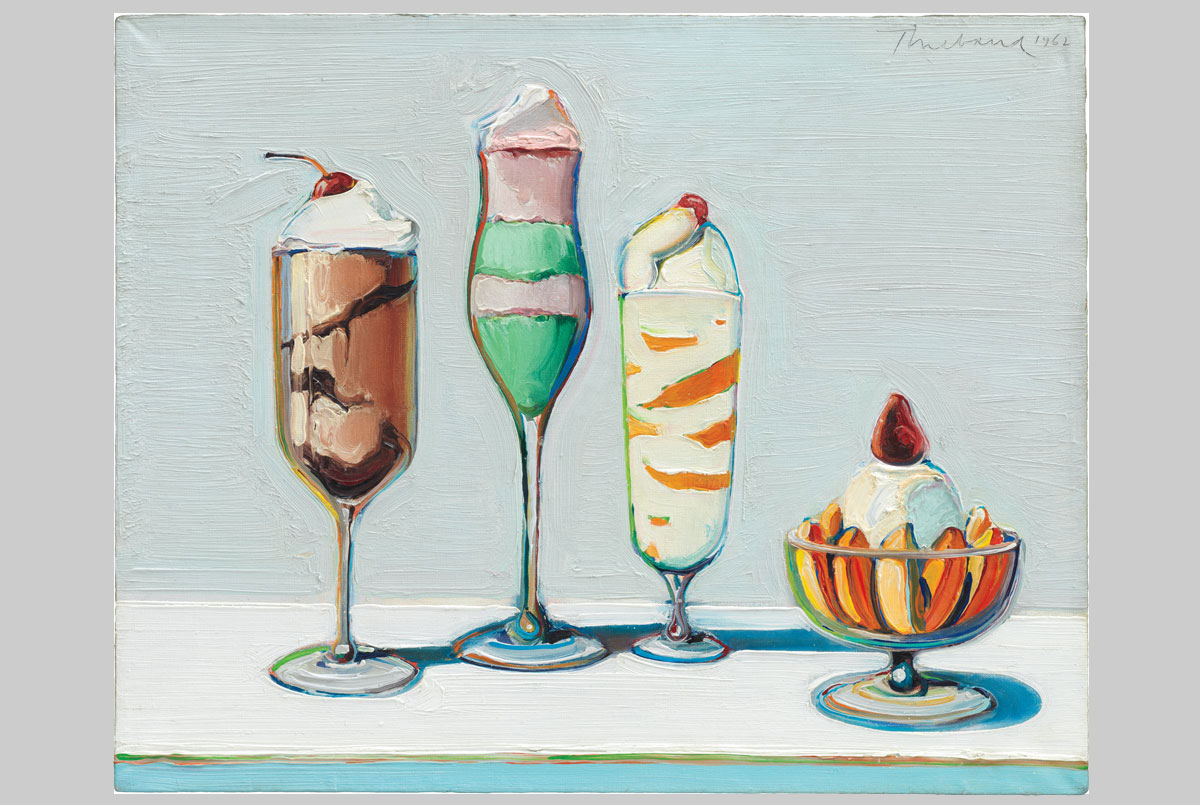 Four ice cream sundaes in different shaped glasses.