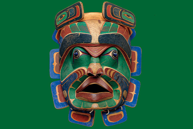 Enlargeable photo of a brightly painted mask depicting a colorful humanoid face