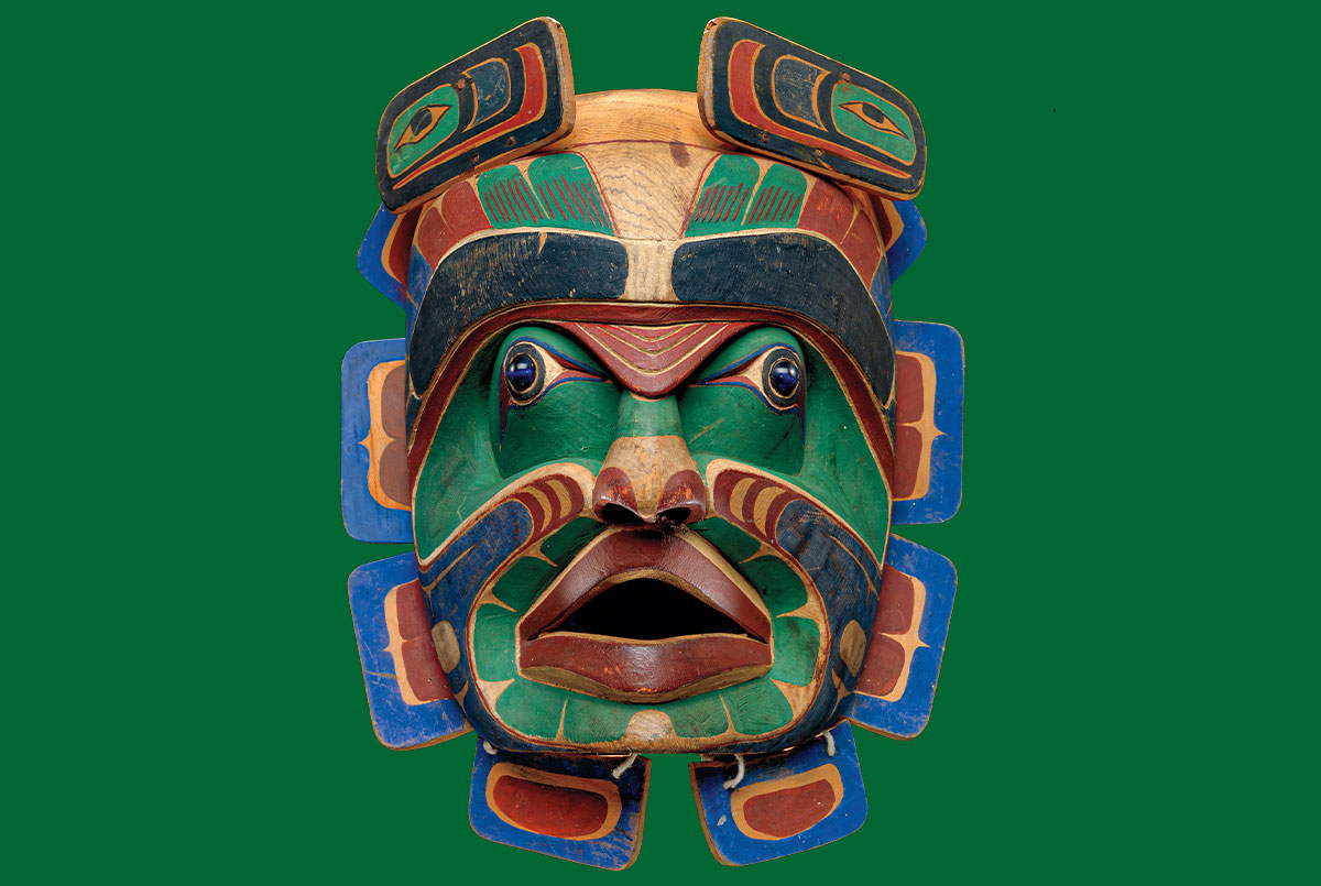 Photo of a brightly painted mask depicting a colorful humanoid face