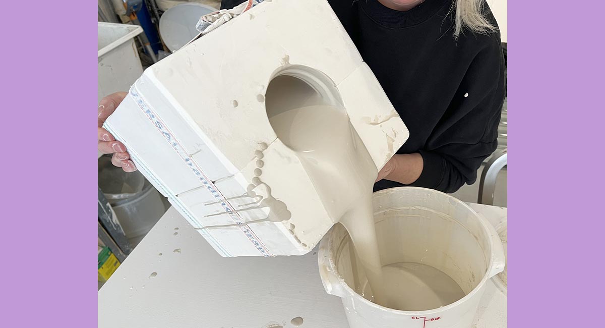 Image of artist pouring excess liquid clay into bucket