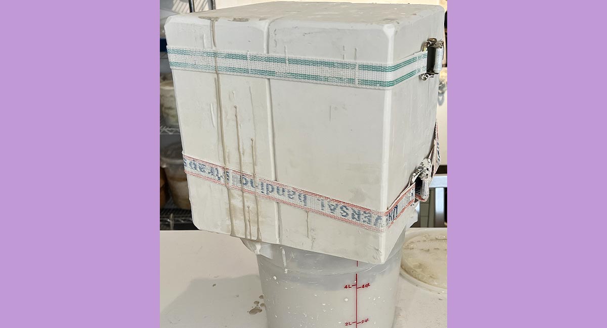 Image of liquid clay dripping into a bucket