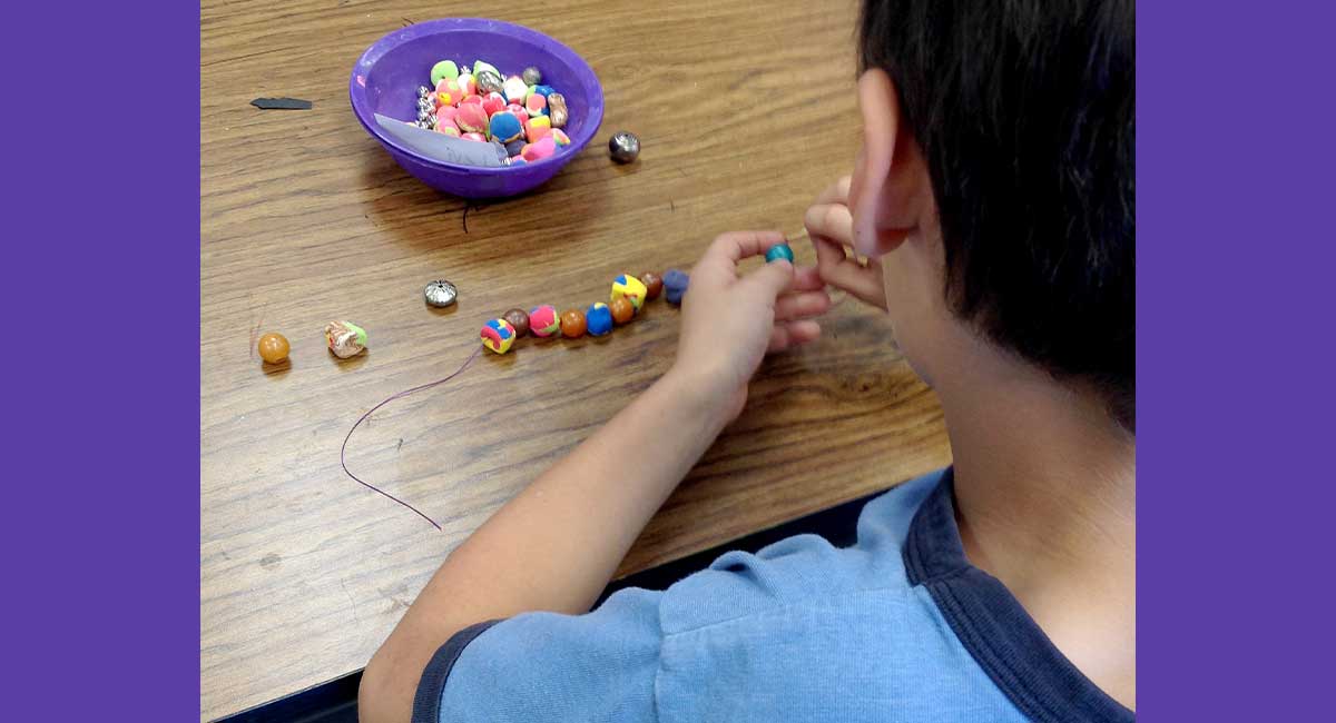 Image of a student making a bracelet