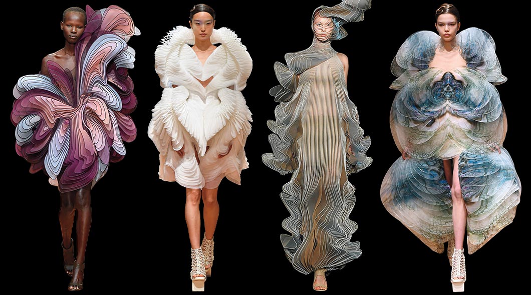 Four runway models wearing dresses with a similar wave theme